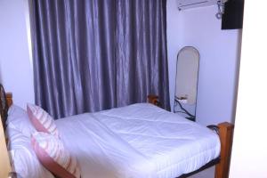 a bedroom with a bed with a mirror and a window at Résidence reine lumière in Libreville