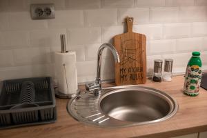 a kitchen counter with a sink and a wooden cutting board at Little Vienna Silver Apartment in Varaždin