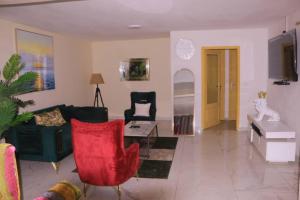 ein Wohnzimmer mit roten Stühlen und einem Sofa in der Unterkunft Résidence reine lumière in Libreville
