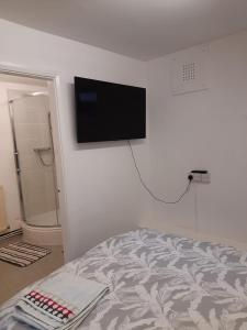 a bedroom with a bed and a flat screen tv on the wall at Private Ensuite Room next to A34 in Birmingham