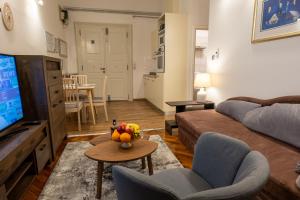 a living room with a couch and a table with a bowl of fruit at Little Vienna Silver Apartment in Varaždin