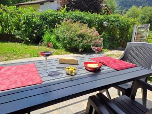 - une table de pique-nique avec deux verres de vin et de fromage dans l'établissement Villetta singola con giardino Cottage Ghisallo zona Bellagio, à Magreglio