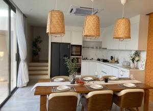 Una cocina con una gran mesa y sillas de madera. en Tank Villa, en Phuket