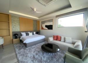 una habitación de hotel con una cama y un sofá en Tank Villa, en Phuket