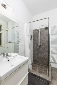 een witte badkamer met een wastafel en een douche bij Venus Apartments - Keleti I in Boedapest