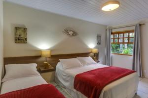 um quarto com 2 camas e uma janela em Pousada Famiglia Bartho em Espirito Santo Do Pinhal
