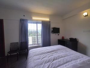 um quarto com uma cama grande e uma janela em Acon Resorts em Kodaikanal