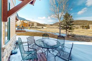 una mesa y sillas en un porche con nieve en Cozy Mountain Retreat, en South Fork