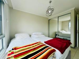Un dormitorio con una cama con una manta roja. en Ocean drive 2 full amenities, en Punta del Este