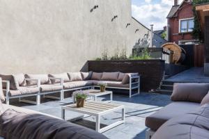 un grupo de sofás sentados en un patio en Luxueus vakantiehuis in hartje Ronse met 7 slaapkamers & badkamers, en Ronse