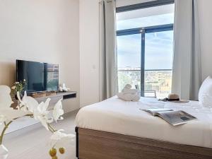 杜拜的住宿－Key View - Laya Heights，一间卧室设有一张床、电视和窗户