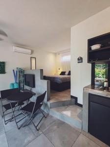 un salon avec une table et des chaises ainsi qu'une chambre dans l'établissement Casa Adams - Apartamentos Adams, à Tamarindo
