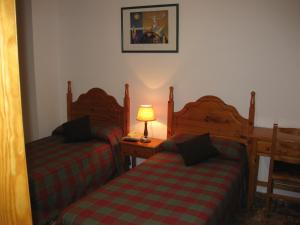 a bedroom with two beds and a lamp on a table at Hostal Alvaro I in Alborea