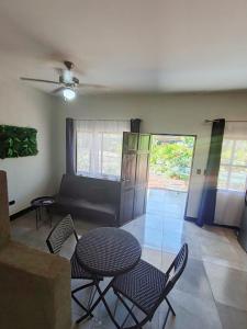 uma sala de estar com uma mesa e cadeiras e um sofá em Casa Adams - Apartamentos Adams em Tamarindo