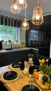 a kitchen with a wooden table with wine glasses at Domki Lubiane in Brenna