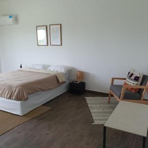 a white bedroom with a bed and a chair at Casa en Laguna Soto Sur in Corrientes