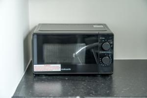 a black toaster oven sitting on top of a counter at Cozy Studio Flat- Dalston Central in London