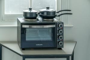 a toaster oven with two pots on top of it at Cozy Studio Flat- Dalston Central in London