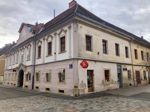 an old white building on the side of a street at Little Vienna Silver Apartment in Varaždin
