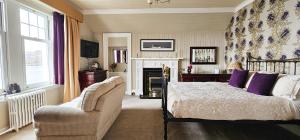 a bedroom with a bed and a couch and a chair at Ards House in Oban