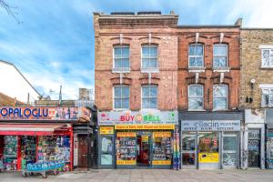 a brick building with shops on a city street at Cozy Studio Flat- Dalston Central in London