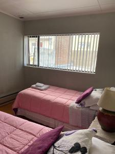 een slaapkamer met 2 bedden en een raam bij Karol Hostal in Punta Arenas