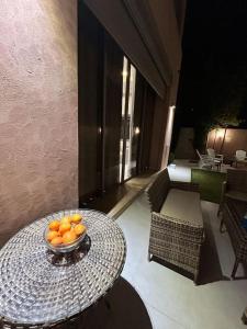 un bol d'oranges sur une table sur une terrasse dans l'établissement Villa djelloul, à Marrakech