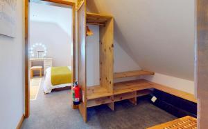 a room with a staircase with a wooden book shelf at CROYDE THATCHERS HIDEAWAY 2 Bedrooms in Croyde