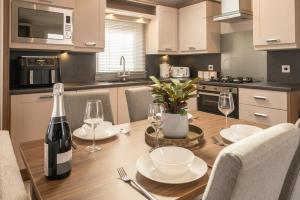 a kitchen with a wooden table with a bottle of wine at 62 Meadow View in Ilfracombe