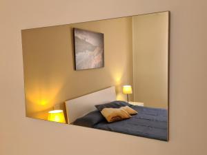 a mirror reflecting a bedroom with a bed in it at Villaggio Mietta in Castiglioncello