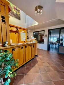 a large kitchen with wooden cabinets and a tile floor at Hotel Zur alten Schmiede in Schaprode