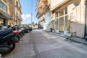 a row of motorcycles parked in a parking lot next to buildings at Corfu Central Casa Seniora Stamy in Ágios Rókkos