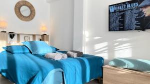 a bedroom with a blue bed with blue sheets at Le bohème in La Houssaye-en-Brie