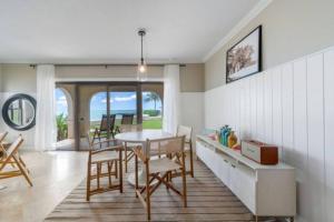 a dining room with a table and chairs and the ocean at George Town Villas 118 in George Town