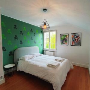 1 dormitorio con 1 cama con pared verde en Maison de charme au cœur de Genève ! en Ginebra