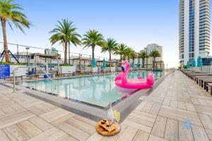 a pool with a pink flamingo pool noodle in the middle at High Floor with Stunning Views, Amazing Pools in Hollywood