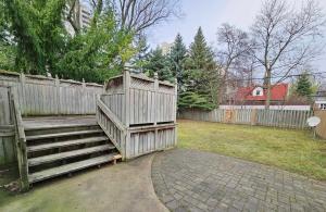 eine Holzbank neben einem Zaun in der Unterkunft Beautiful Room at Yonge and Sheppard and North York Centre in Toronto