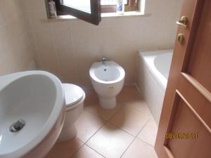 ein Badezimmer mit einem WC, einem Waschbecken und einer Badewanne in der Unterkunft casa fiano in Fiano Romano