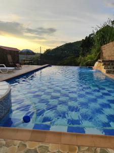una gran piscina azul con mesa y sombrilla en Ecohotel Java en Manizales