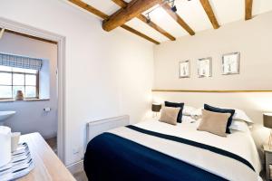 a bedroom with a large bed and a bathroom at The Crewe and Harpur in Buxton