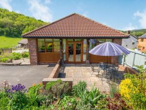 Cette maison dispose d'une terrasse avec un parasol. dans l'établissement The Carthouse, à Hereford