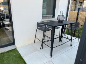 a black table and two chairs on a patio at studio Lauralex in Montardon