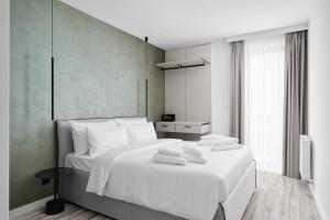 a bedroom with a white bed with towels on it at Hotel Collect & Residence in Budapest