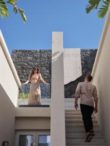 a man walking down a staircase with a woman on the wall at Alaso Design Suites in Fira