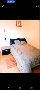 a bedroom with a bed and a lamp on a wall at Torres de la Alborada in Ipiales