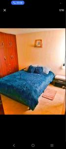 a bedroom with a bed with a blue blanket at Torres de la Alborada in Ipiales