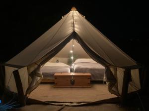 een witte tent met een bed en een tafel bij Glamping 3 Idiomas in El Sargento