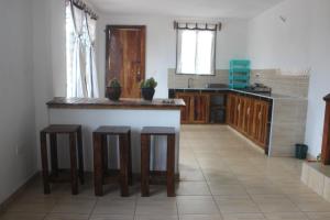 a kitchen with a counter and stools in a room at Gemini Villas in Kijiwetanga