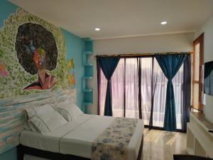 um quarto com uma cama com um quadro na parede em Avadia del Mar em Cartagena de Indias