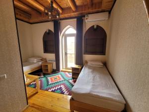 a small room with a bed and a window at Khiva Siyovush Hotel in Khiva